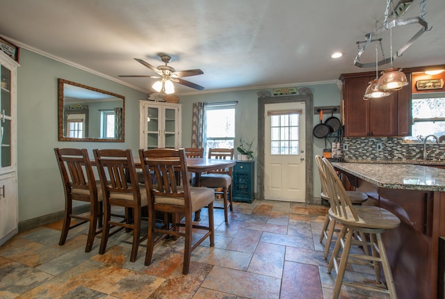 dining room featuring ceiling fan, sink, and ornamental molding