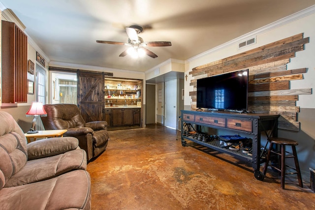 living room with ceiling fan, a barn door, and ornamental molding