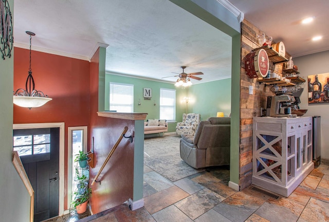 entryway with ceiling fan and crown molding