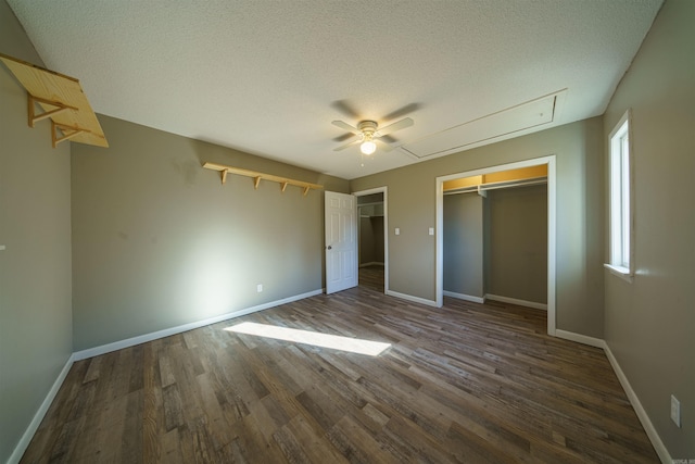 unfurnished bedroom featuring ceiling fan, a textured ceiling, dark hardwood / wood-style floors, and a closet