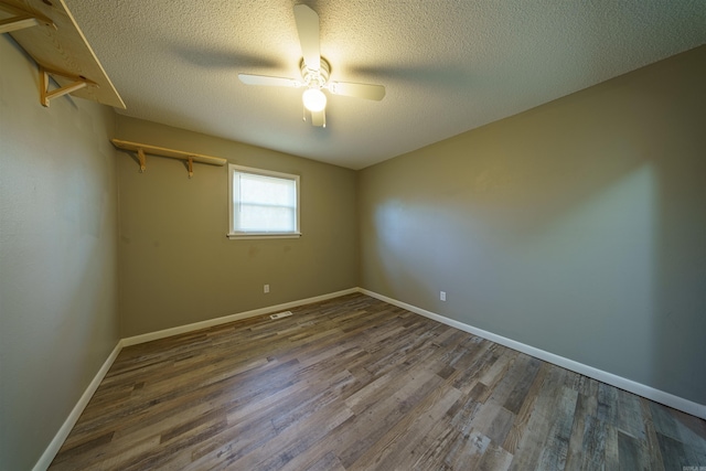 unfurnished room with ceiling fan, dark hardwood / wood-style flooring, and a textured ceiling