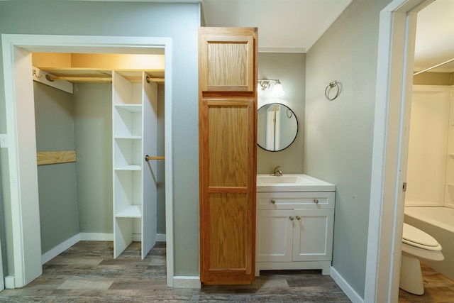 full bathroom featuring hardwood / wood-style floors, shower / tub combination, vanity, toilet, and crown molding