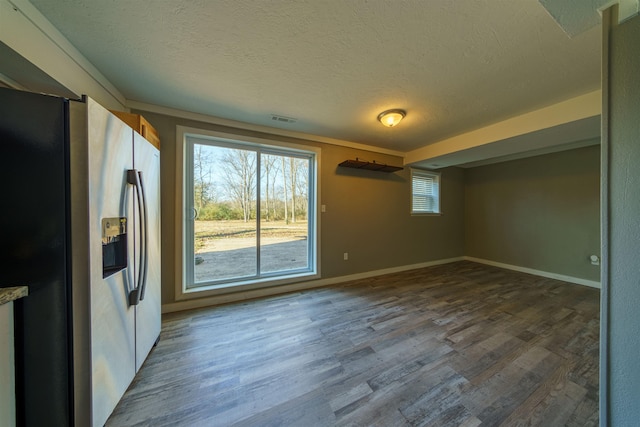 unfurnished room with a textured ceiling and hardwood / wood-style flooring