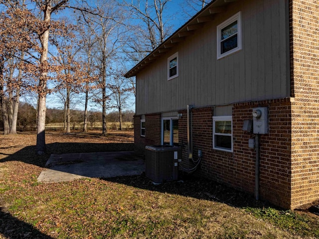 view of side of property featuring central air condition unit and a patio