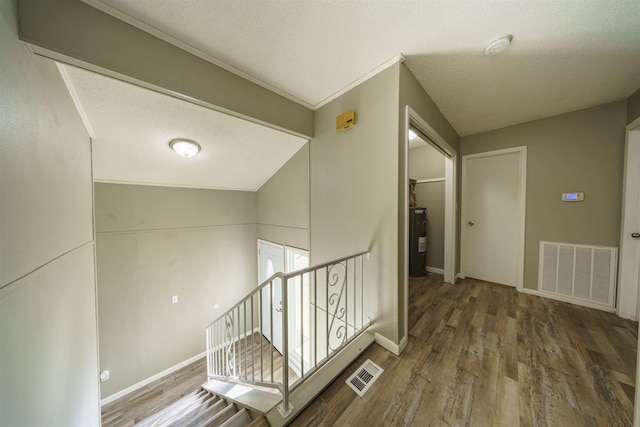 hall featuring dark wood-type flooring, a textured ceiling, water heater, and vaulted ceiling