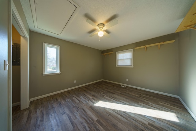 spare room featuring ceiling fan, dark wood-type flooring, and a textured ceiling