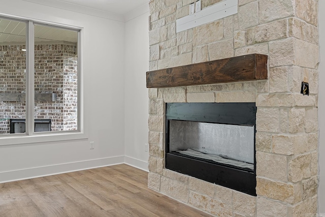 details with hardwood / wood-style flooring, ornamental molding, and a fireplace