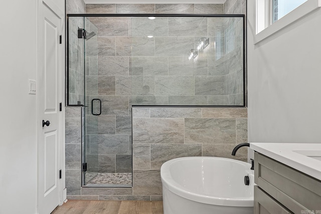 bathroom with shower with separate bathtub, hardwood / wood-style floors, and vanity