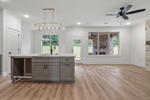 kitchen with sink, pendant lighting, a center island, and a chandelier