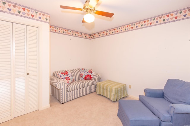 sitting room featuring ceiling fan and light colored carpet