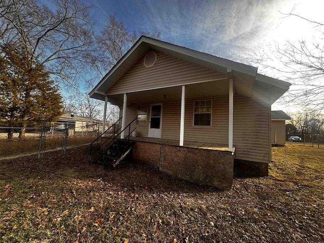 rear view of property featuring covered porch