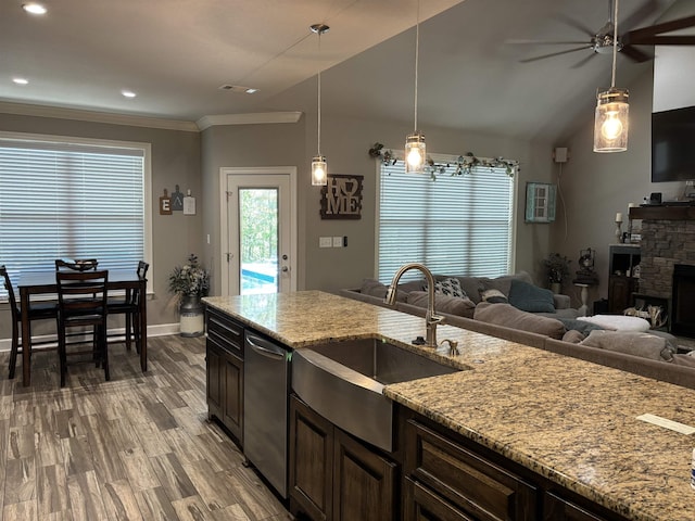 kitchen with light stone countertops, dishwasher, decorative light fixtures, sink, and ceiling fan