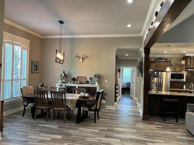 dining room featuring crown molding, hardwood / wood-style flooring, and sink