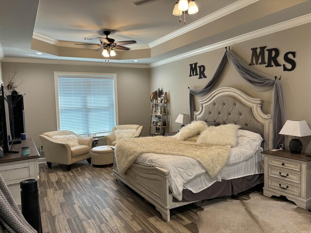 bedroom with a raised ceiling, ceiling fan, dark hardwood / wood-style floors, and ornamental molding