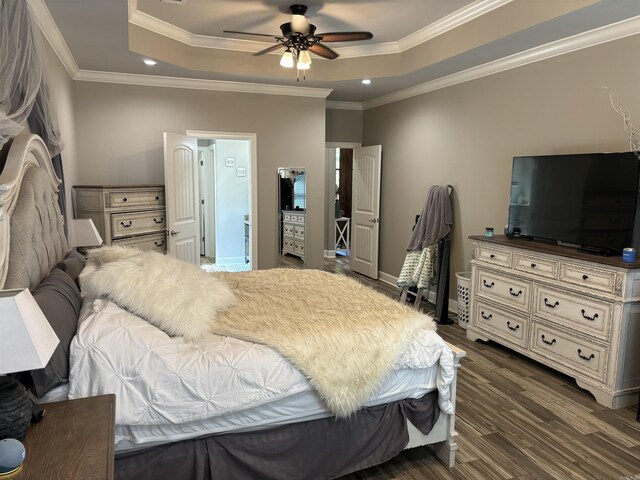 bedroom with ceiling fan, dark wood-type flooring, crown molding, and a raised ceiling