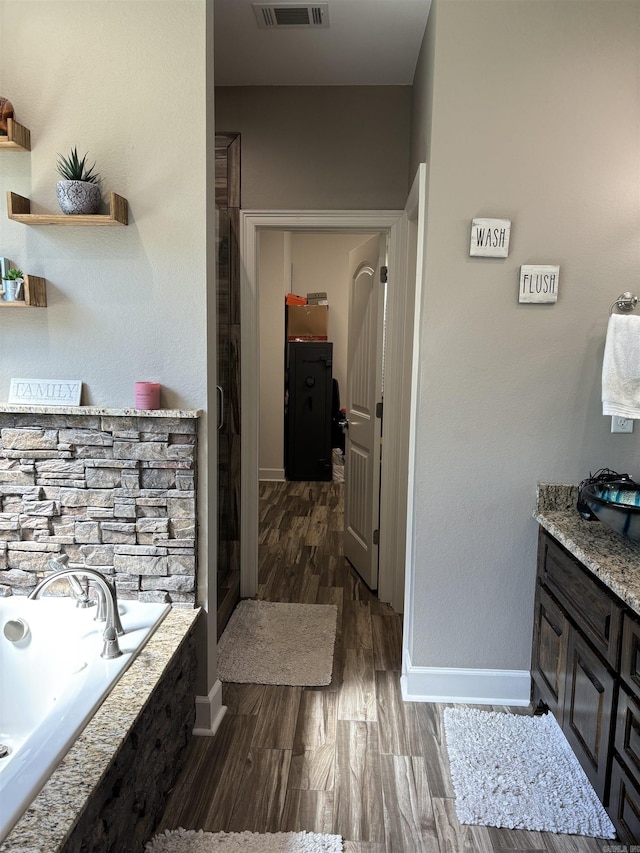 bathroom featuring vanity, independent shower and bath, and hardwood / wood-style floors