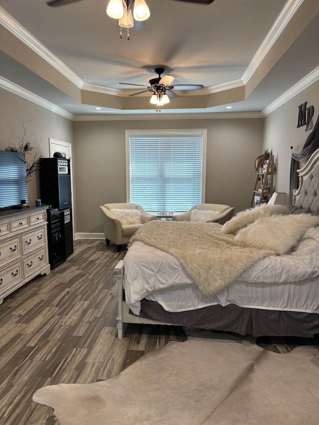 bedroom with ceiling fan, dark wood-type flooring, a tray ceiling, and crown molding