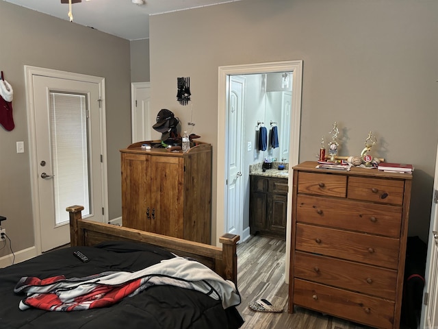 bedroom with ensuite bathroom and light hardwood / wood-style floors