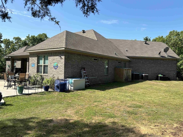 back of property featuring a yard, central AC unit, and a patio