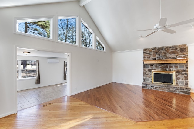 unfurnished living room with wood-type flooring, a stone fireplace, high vaulted ceiling, a wall mounted AC, and ceiling fan