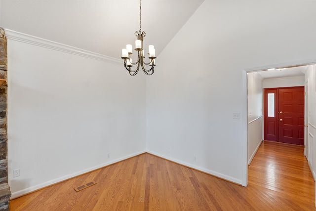 unfurnished room featuring vaulted ceiling, crown molding, a chandelier, and hardwood / wood-style flooring