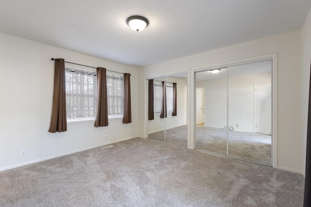 unfurnished bedroom with carpet and multiple closets