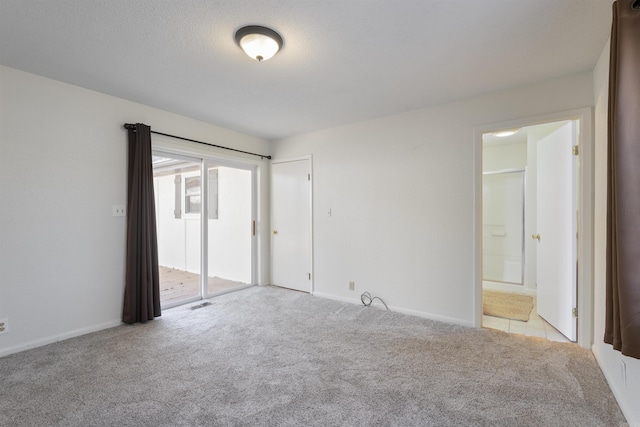 unfurnished bedroom with ensuite bathroom and light colored carpet