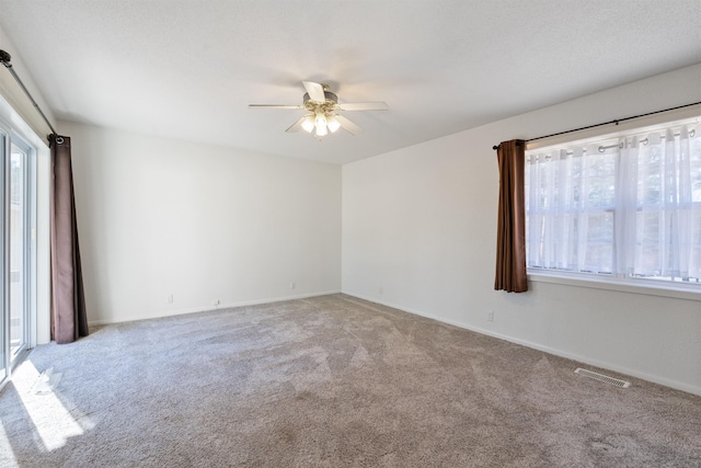 carpeted empty room featuring ceiling fan