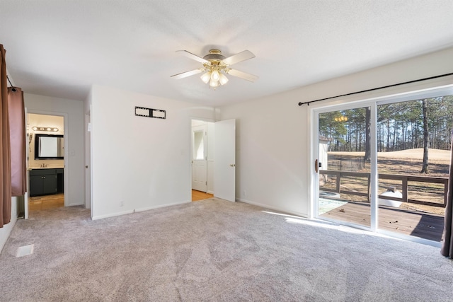 unfurnished bedroom with a textured ceiling, connected bathroom, access to outside, ceiling fan, and light colored carpet