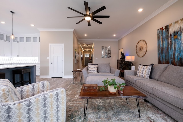 living room with ceiling fan, wood-type flooring, and crown molding