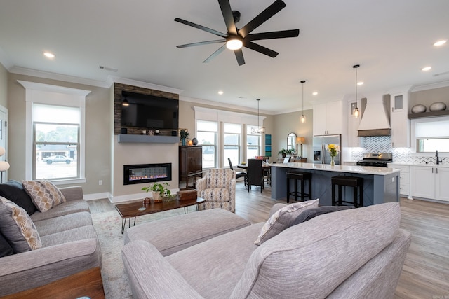 living room featuring light hardwood / wood-style floors, ceiling fan, and a fireplace