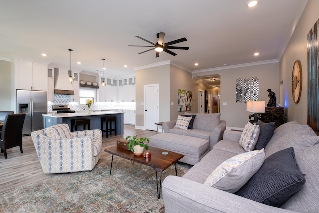 living room with light wood-type flooring, ceiling fan, and crown molding