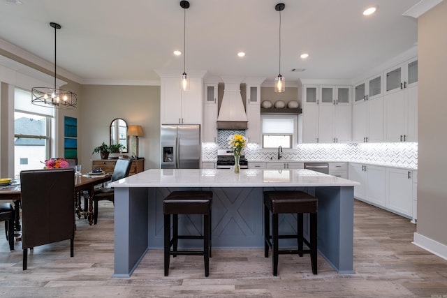 kitchen with a kitchen bar, a center island, stainless steel appliances, and custom range hood