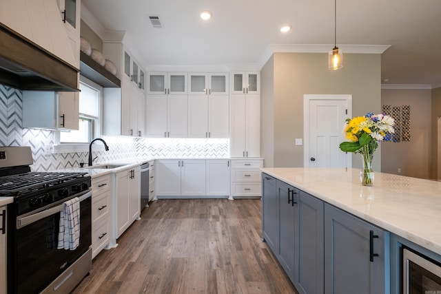 kitchen with white cabinetry, stainless steel appliances, decorative backsplash, pendant lighting, and sink