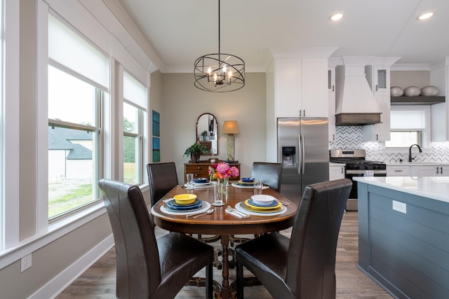 dining room with dark wood-type flooring, a chandelier, a wealth of natural light, and sink