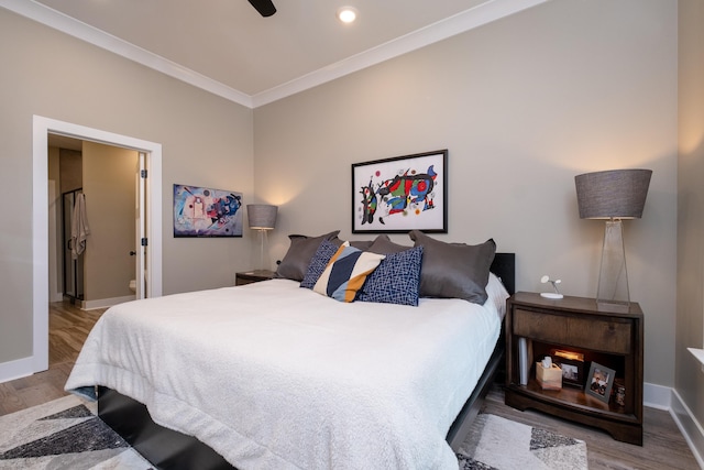 bedroom featuring ceiling fan, crown molding, light hardwood / wood-style floors, and ensuite bath