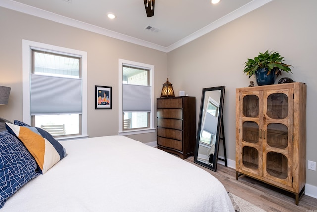 bedroom featuring ceiling fan, crown molding, and hardwood / wood-style flooring