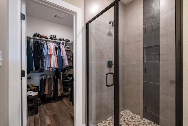 bathroom featuring an enclosed shower and hardwood / wood-style flooring