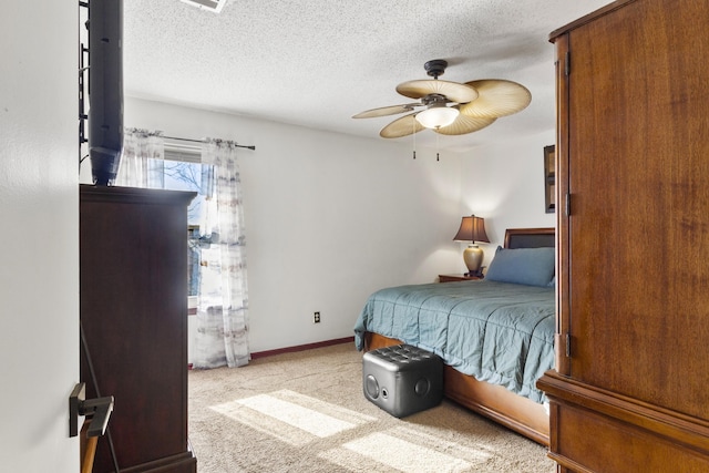 carpeted bedroom with ceiling fan and a textured ceiling