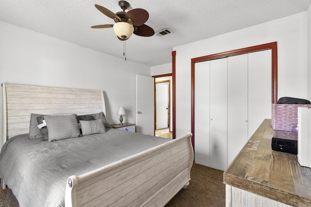 bedroom with ceiling fan, a closet, carpet, and a textured ceiling