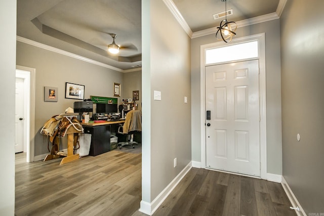 foyer entrance featuring ceiling fan, ornamental molding, wood-type flooring, and a raised ceiling