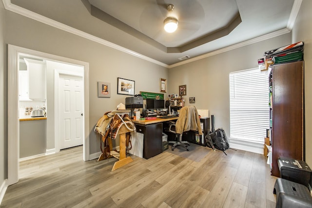 office area with a tray ceiling, ornamental molding, and light hardwood / wood-style flooring