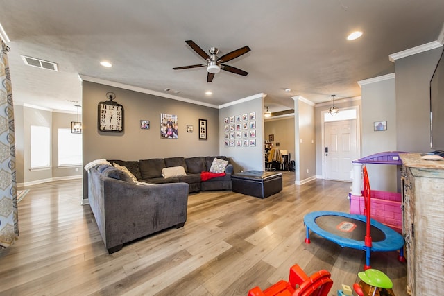 living room featuring ceiling fan, ornamental molding, and light hardwood / wood-style floors