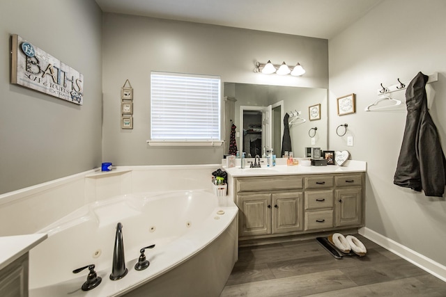 bathroom with a bath, hardwood / wood-style floors, and vanity