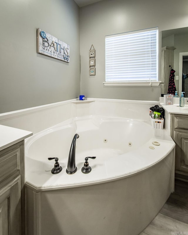 bathroom featuring a washtub and vanity