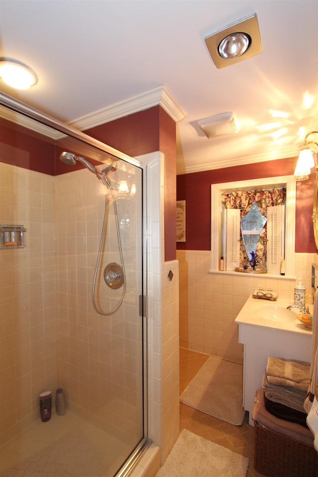 bathroom with vanity, tile walls, tile patterned flooring, crown molding, and an enclosed shower