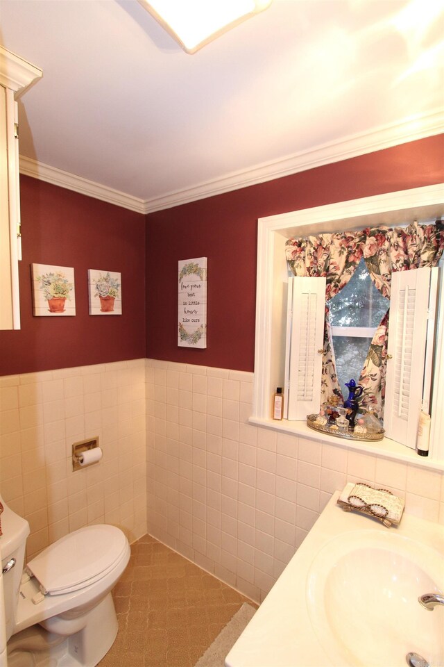 bathroom with toilet, vanity, tile walls, and ornamental molding