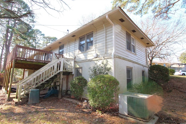 view of side of home with central AC unit and a deck