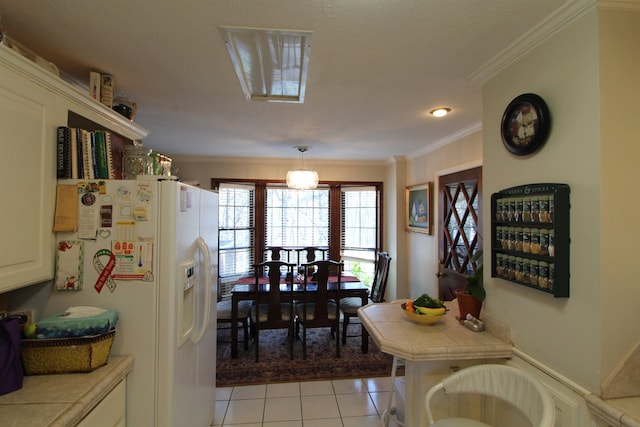 tiled dining space featuring crown molding