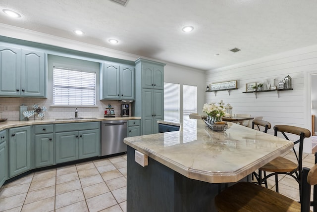 kitchen featuring sink, backsplash, stainless steel dishwasher, and light tile patterned flooring